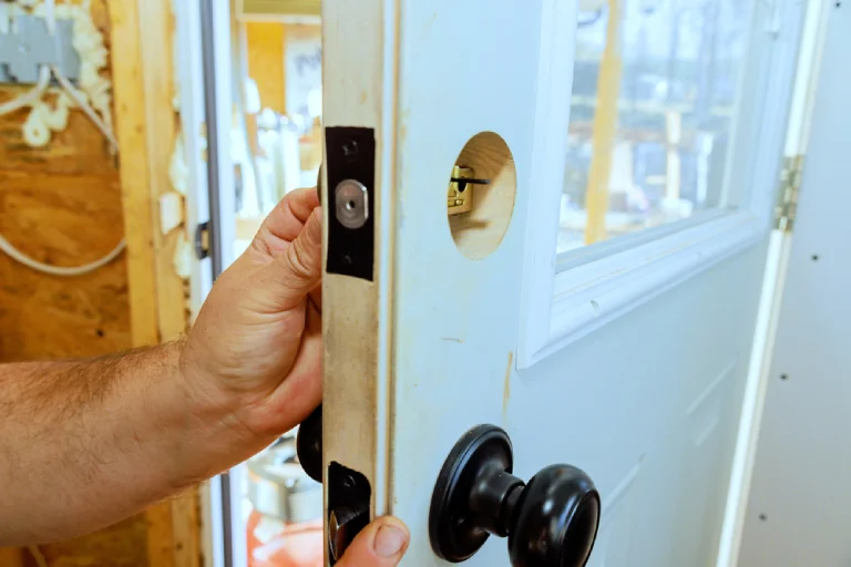 Residential locksmith in Melbourne FL installing new deadbolt and modern door knob hardware for improved home security